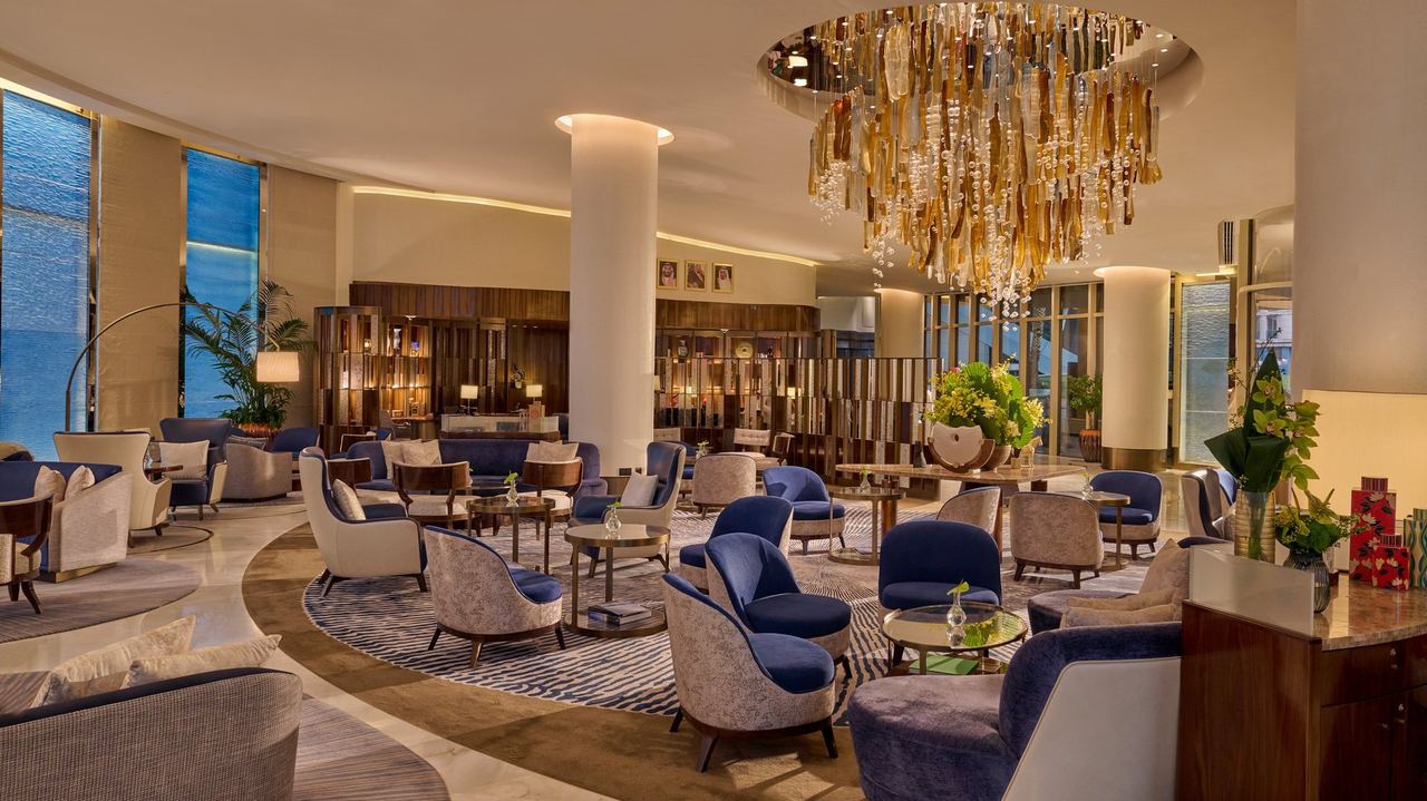 The Mandarin Lounge at Mandarin Oriental Al Faisaliah, blue velvet armchairs under an amber glass chandelier
