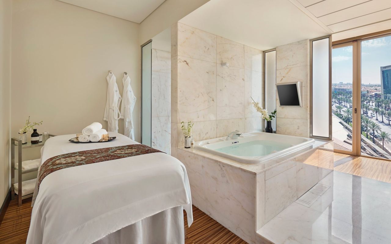 A spa treatment room at Mandarin Oriental Al Faisaliah, with a marble bath by the window