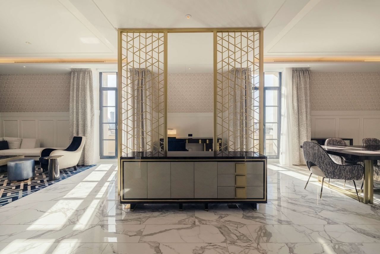 A suite at Mansard Riyadh, marble floors and a brass lattice screen in the afternoon sun