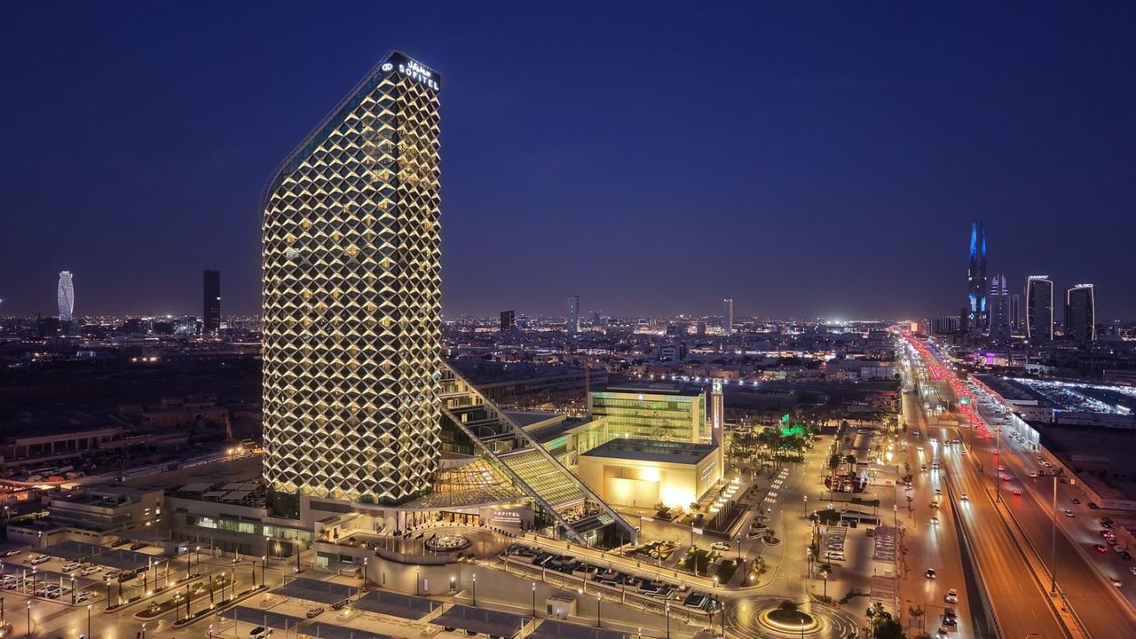 Sofitel Riyadh at night, its latticed tower lit above the city